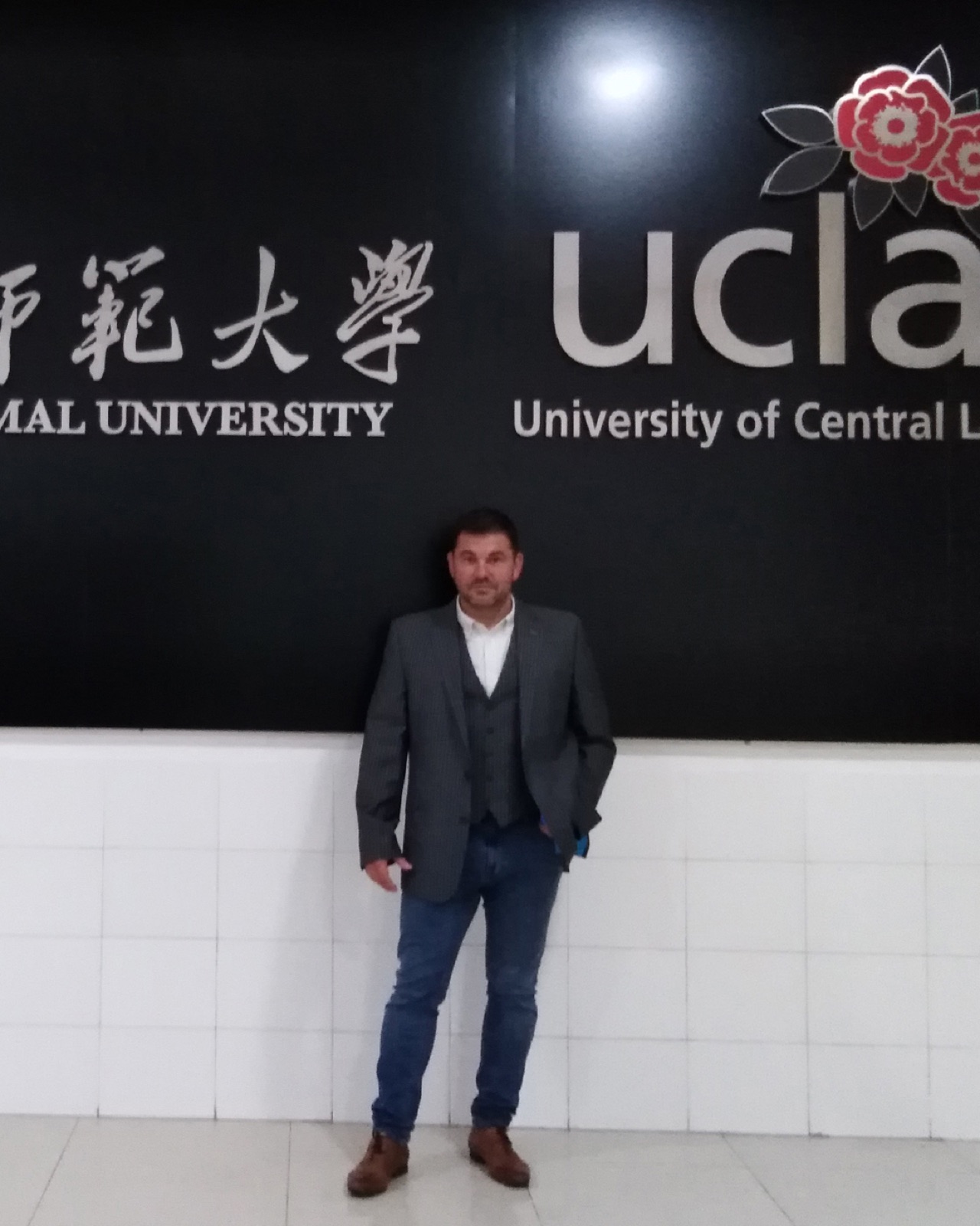 Student-athlete walking across a UK university campus with kit bag